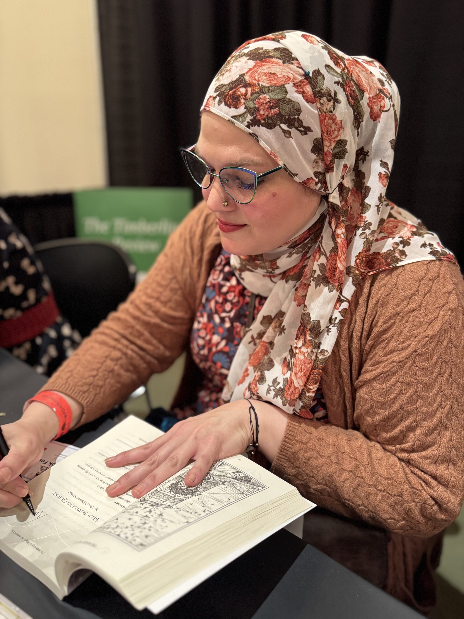 Photo of Niyyah Ruscher Haqq signing books